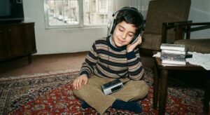 تصویر کودکی رضا پیشرو در جال گوش دادن به آلبوم توپاک در نظام آباد تهران